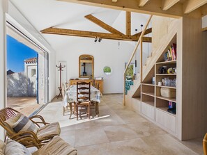 A spacious room with a dining area, a staircase, and a bookshelf. - By the ocean, 9 guests, garden included (La Guérinière)