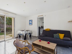 Un espace de vie moderne comprenant un coin repas, un canapé et une table basse.