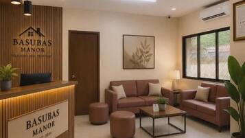 A reception area with a wooden desk, a sofa, and a coffee table.