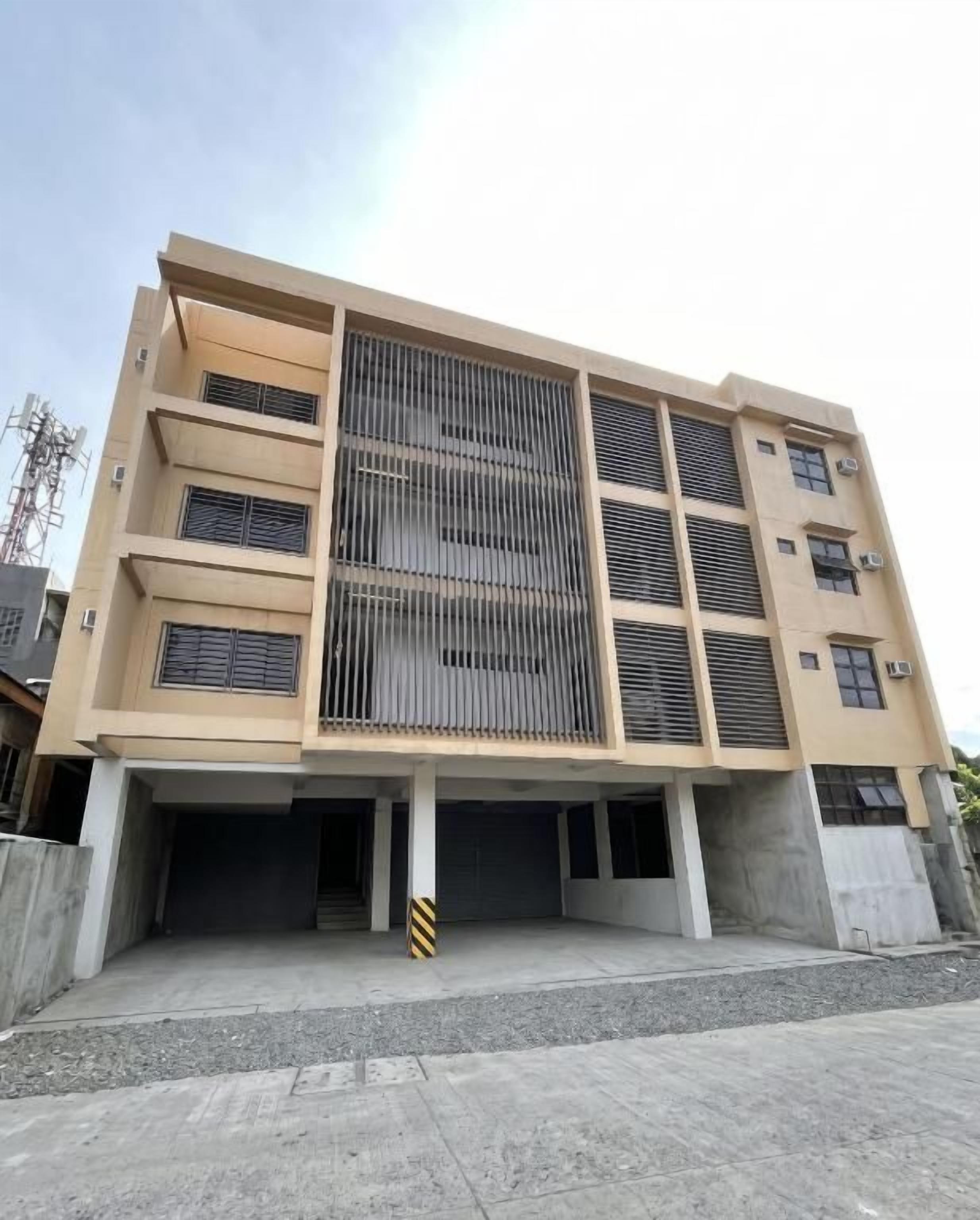 Un edificio de varios pisos con fachada plana, grandes ventanales y un espacio abierto central.