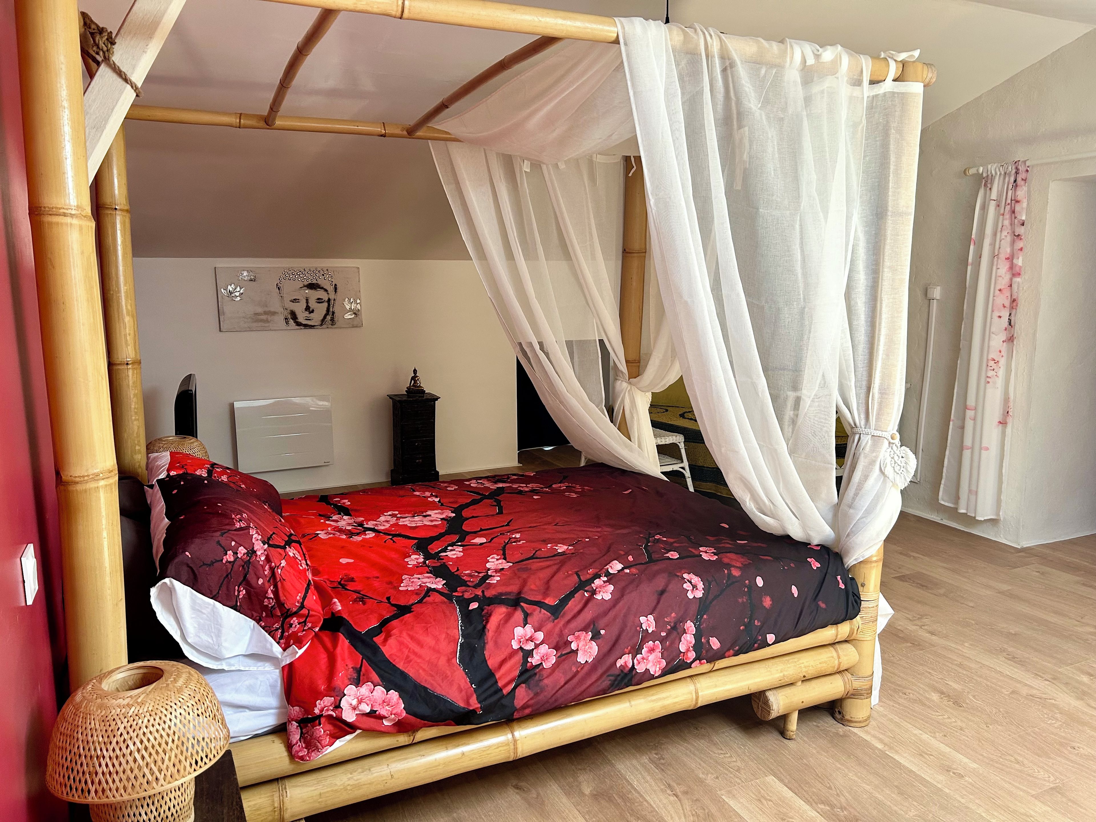 Une chambre dotée d’un lit à baldaquin, d’une petite table, d’un élément décoratif mural et d’un climatiseur fixé au mur.