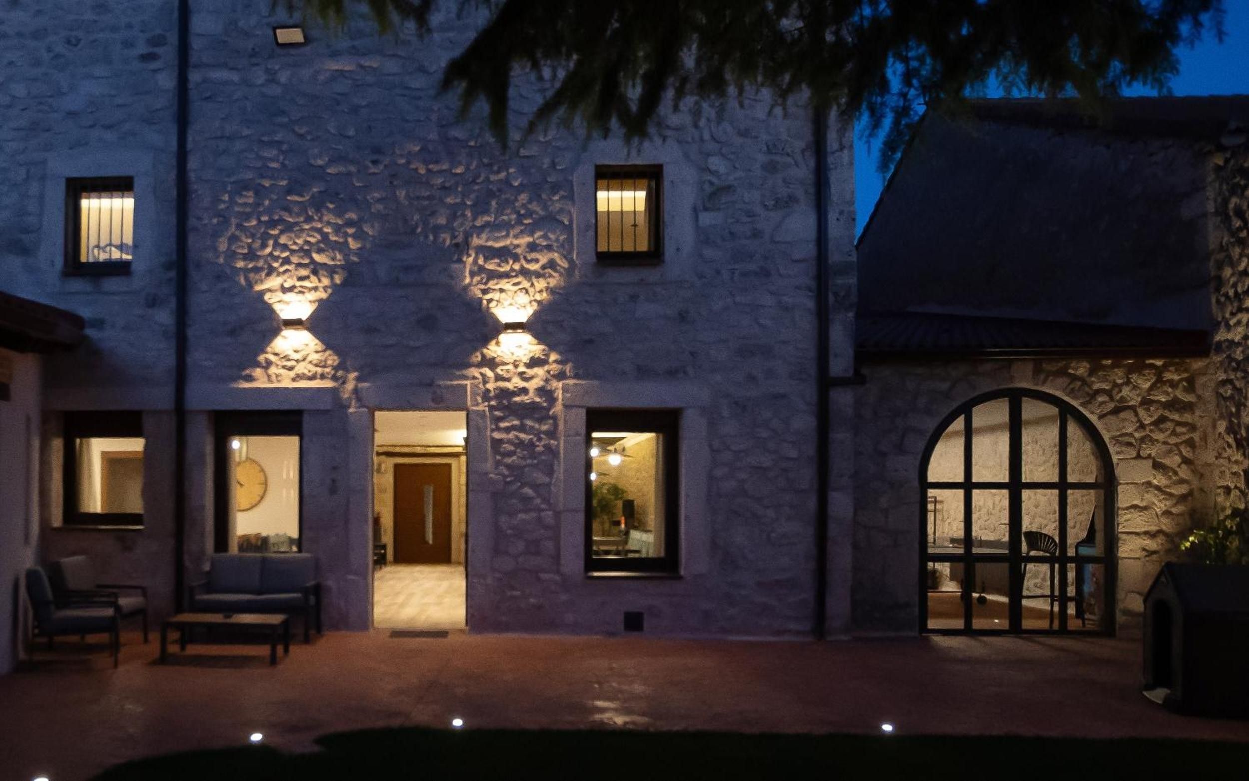 Edificio de piedra con un patio, una puerta y una ventana con vistas.