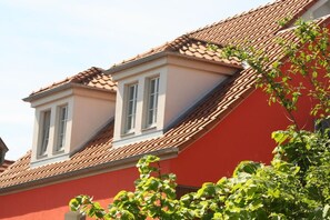 A building with a red facade and a tiled roof. - Holiday apartment with 2 bedrooms (Waren-Müritz)