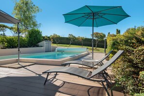A swimming pool with lounge chairs and an umbrella. - Holiday Home 'Maison Joie de Vivre' with Large Fenced Garden, Private Pool, Terraces and AC (Cénac-et-Saint-Julien)