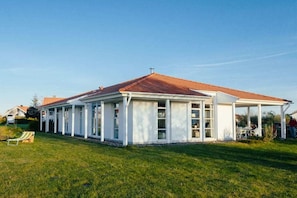Ein einstöckiges Gebäude mit einer überdachten Veranda und einem roten Ziegeldach.