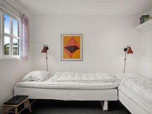 Ein Zimmer mit einem Bett, einem Schreibtisch und einem Fenster.