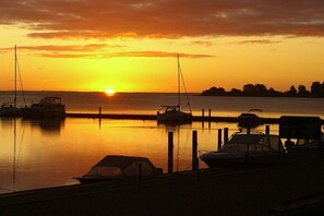Un port de plaisance avec des bateaux amarrés au quai au coucher du soleil.