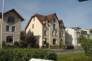 A multi-story residential building with a classic architectural style, featuring a symmetrical facade, multiple windows, and a red-tiled roof. - A2 in the apartment building near Müritz (Waren (Müritz))