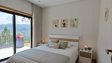 A modern bedroom with a large bed, bedside tables, and artwork on the wall.