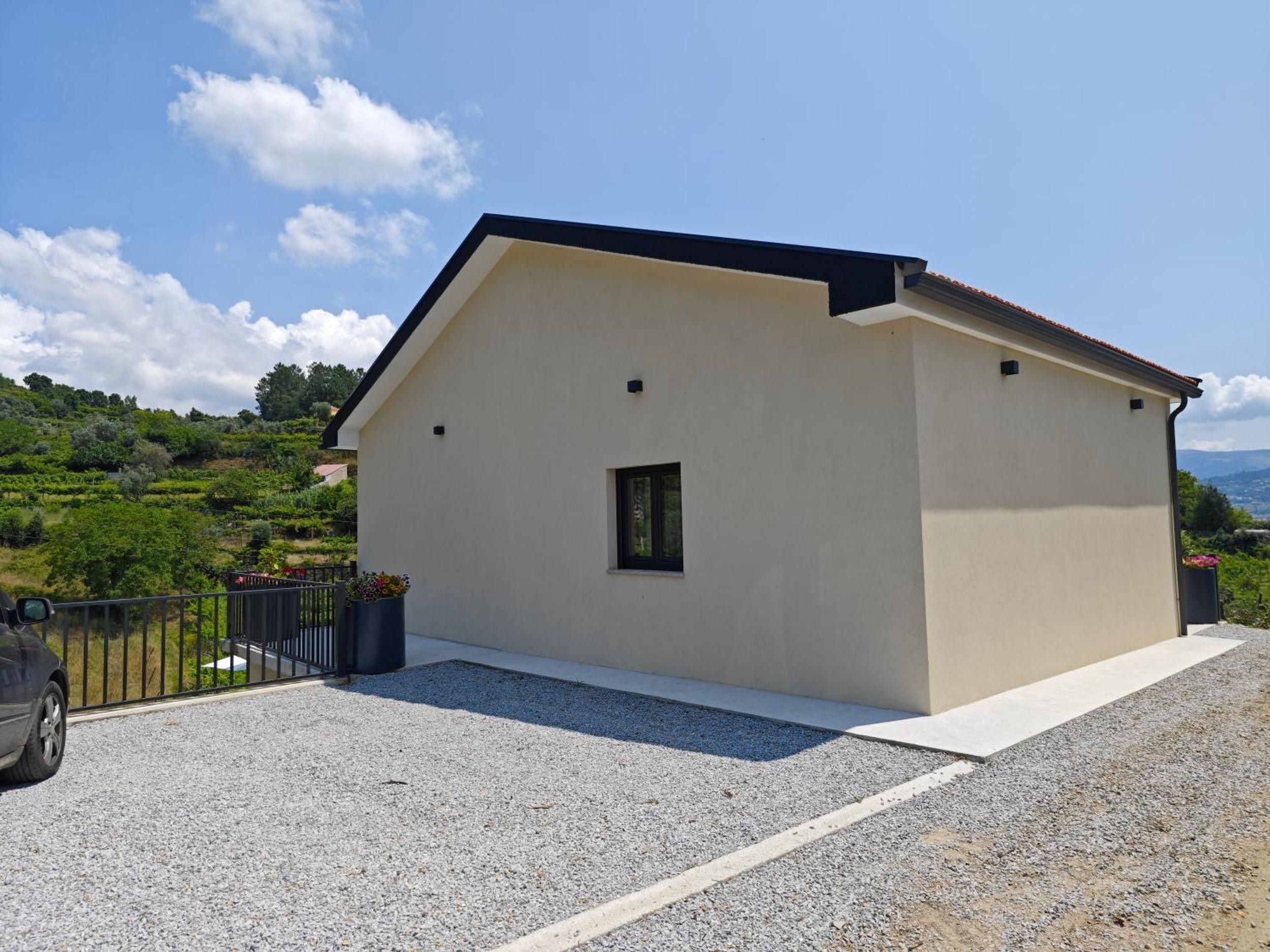 Un bâtiment d’un seul étage, doté d’un toit en pente, d’une petite fenêtre et d’une allée gravillonnée.