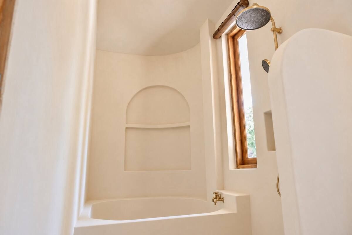 A bathroom with a bathtub, a shower, and a window.