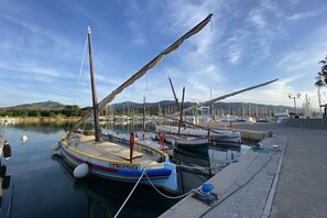 A marina with several boats docked, a clear sky, and a hilly landscape in the background. - Chalet à la maison camping club (Argeles sur mer)