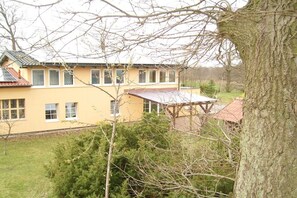 Ein zweistöckiges Gebäude mit gelber Fassade und rotem Dach.