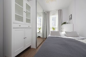Un dormitorio con una cama, un armario y un espejo.