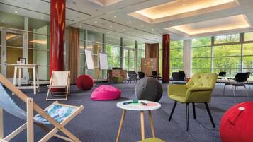 Un espace de détente moderne doté de grandes fenêtres, de sièges confortables et d’une ambiance décontractée.