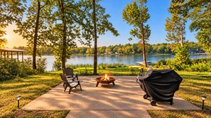 A lakeside patio with a fire pit, outdoor seating, and a grill. - Houston Co Lakefront - Dock, Games, Views (Crockett)