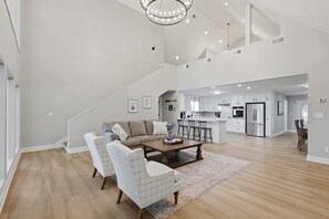 A spacious living area with a sectional sofa, a coffee table, and a dining area with chairs.