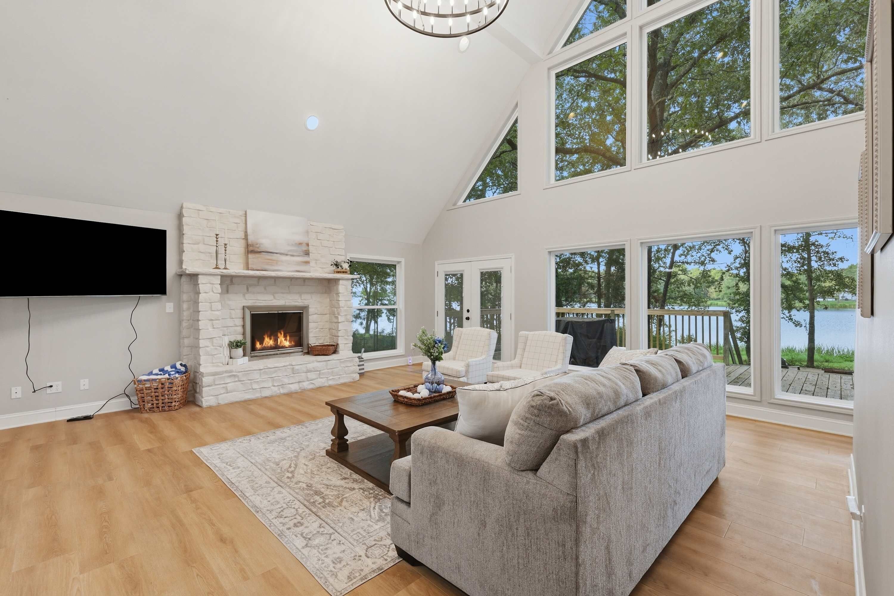 A spacious living room with a fireplace, large windows, and a comfortable seating area.