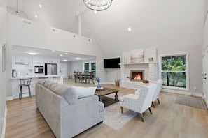 A spacious living area with a fireplace, a dining area, and a kitchen.