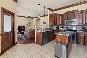 A spacious kitchen with wooden cabinets, a central island, and modern appliances. - 15m to Dyess AFB - 3BR, Fenced Yard (Abilene)