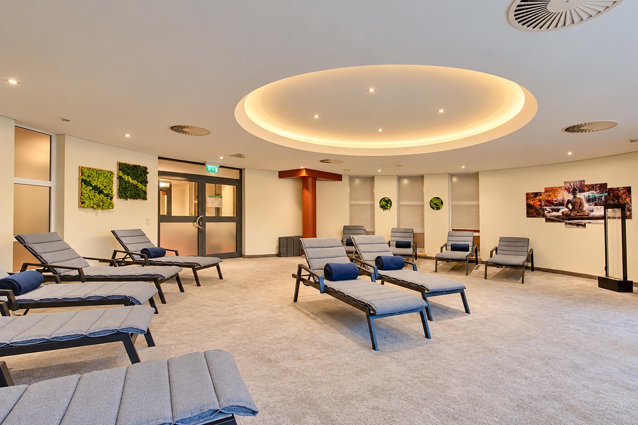 A room with multiple reclining chairs, a reception desk, and a wall-mounted artwork.