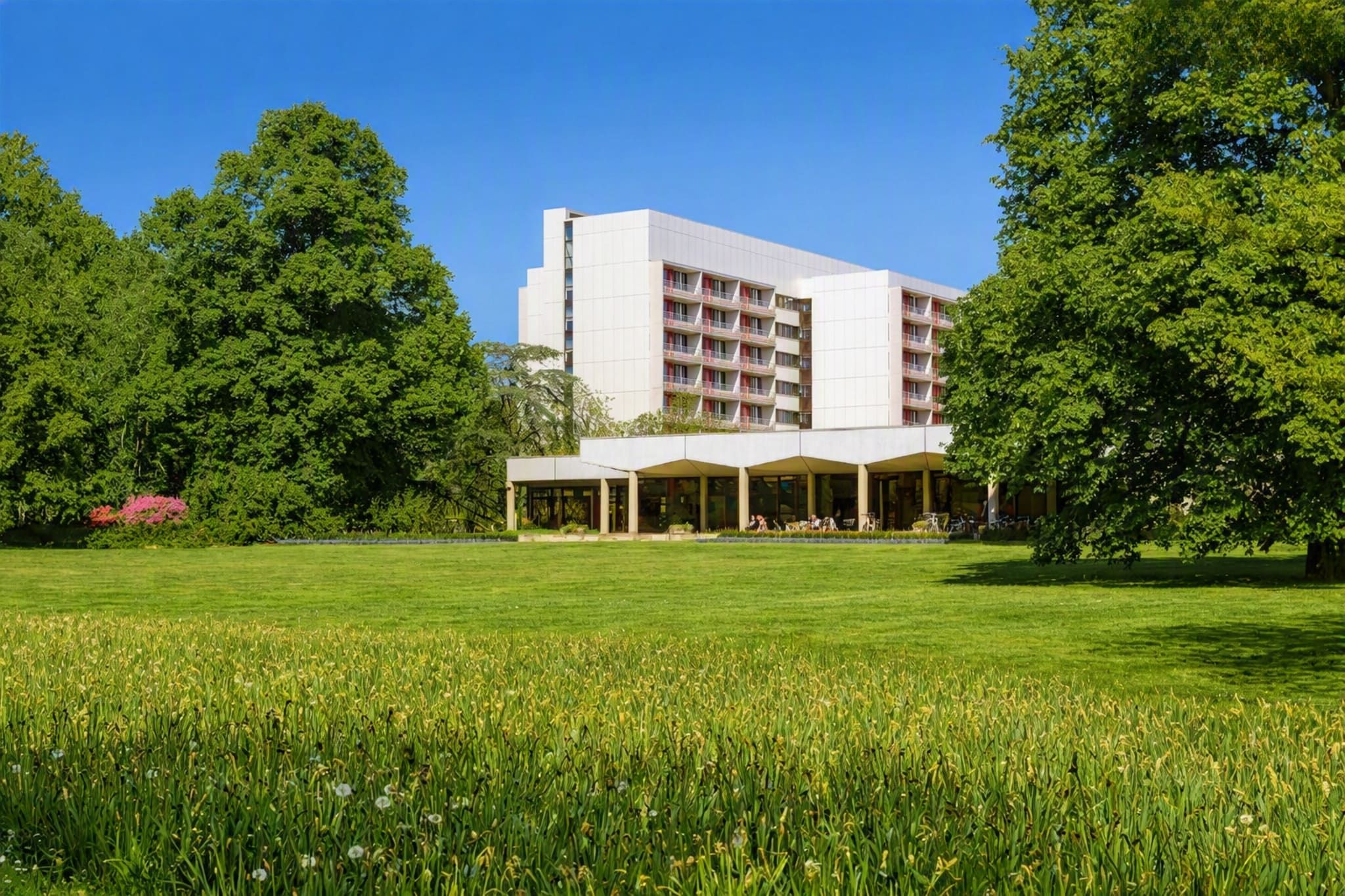 A hotel with a modern design, featuring a flat roof and a large open courtyard.