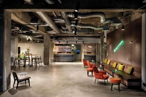 A modern interior with a bar area, seating, and exposed ductwork.