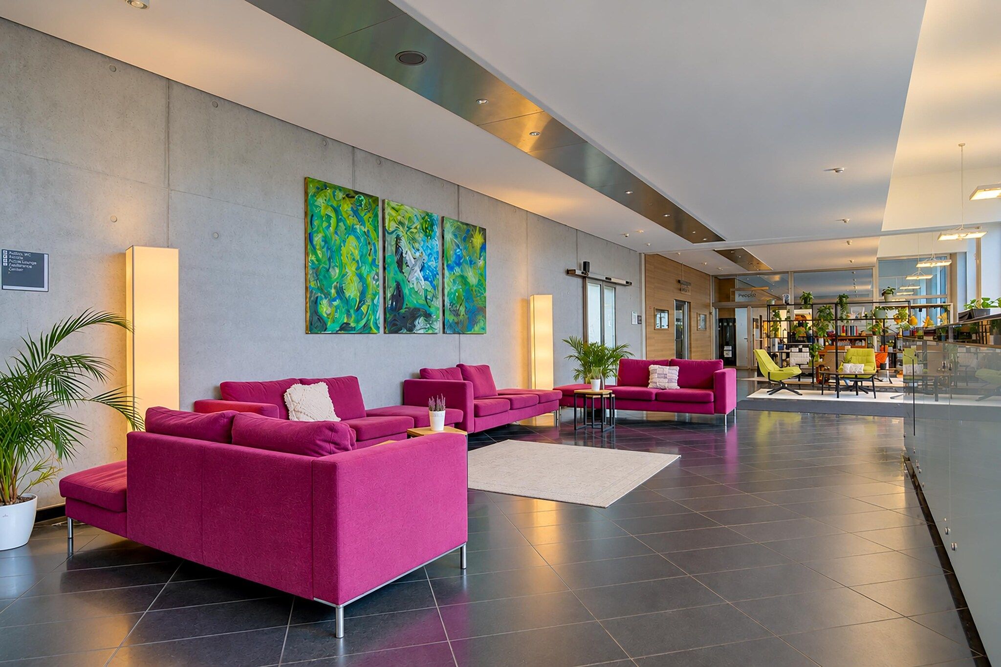 A modern lobby with two sofas, a coffee table, and a bookshelf.