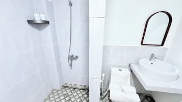 A bathroom with a shower, toilet, sink, and a mirror.
