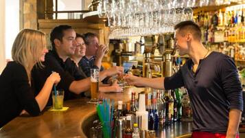 Un espace bar où un barman sert des boissons aux clients.
