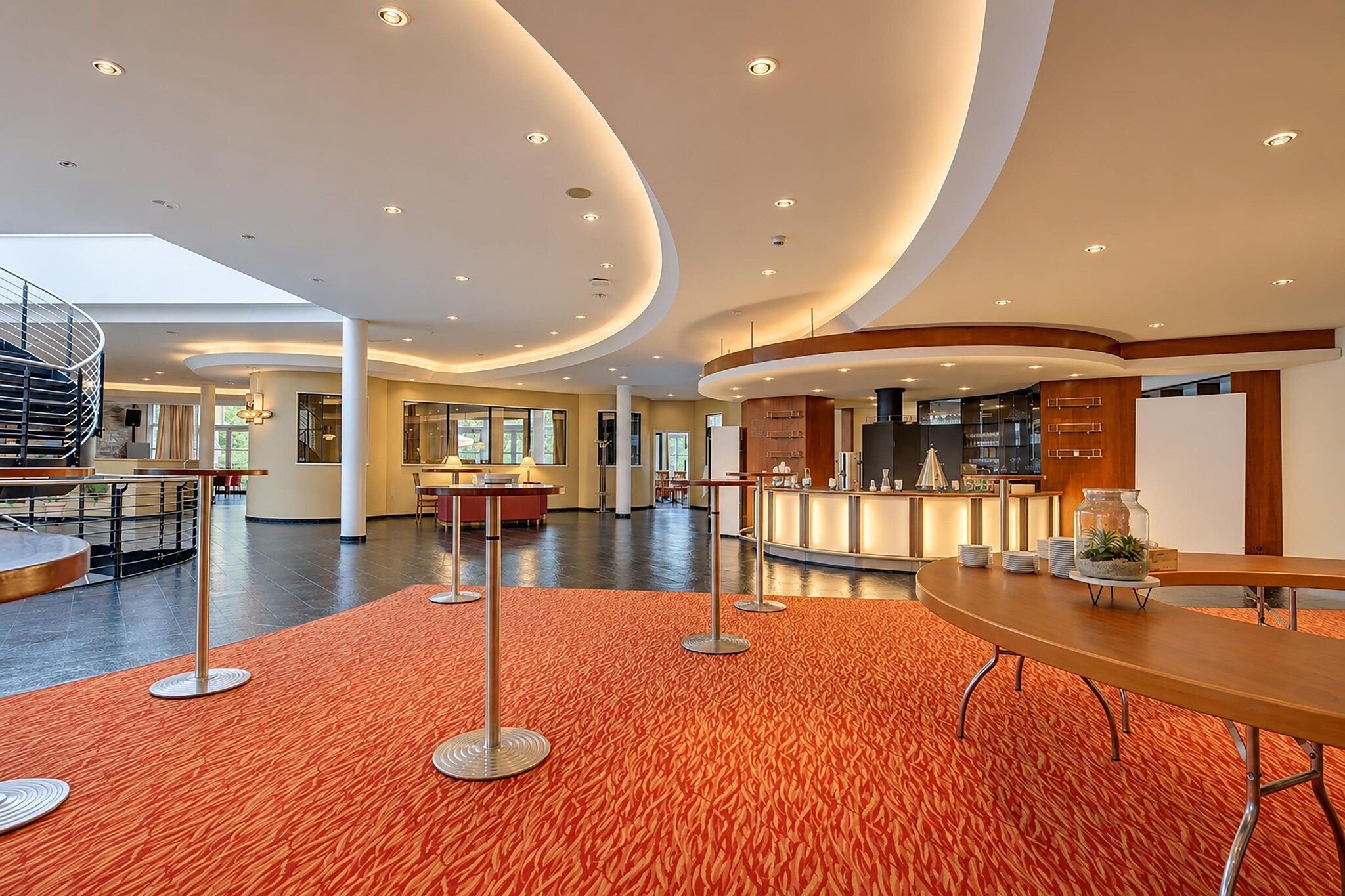 Eine großzügige Lobby mit gewölbter Decke, einer Rezeption und einer Treppe.