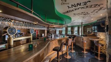 Un espace bar avec un comptoir en bois, des tabourets de bar et une horloge.