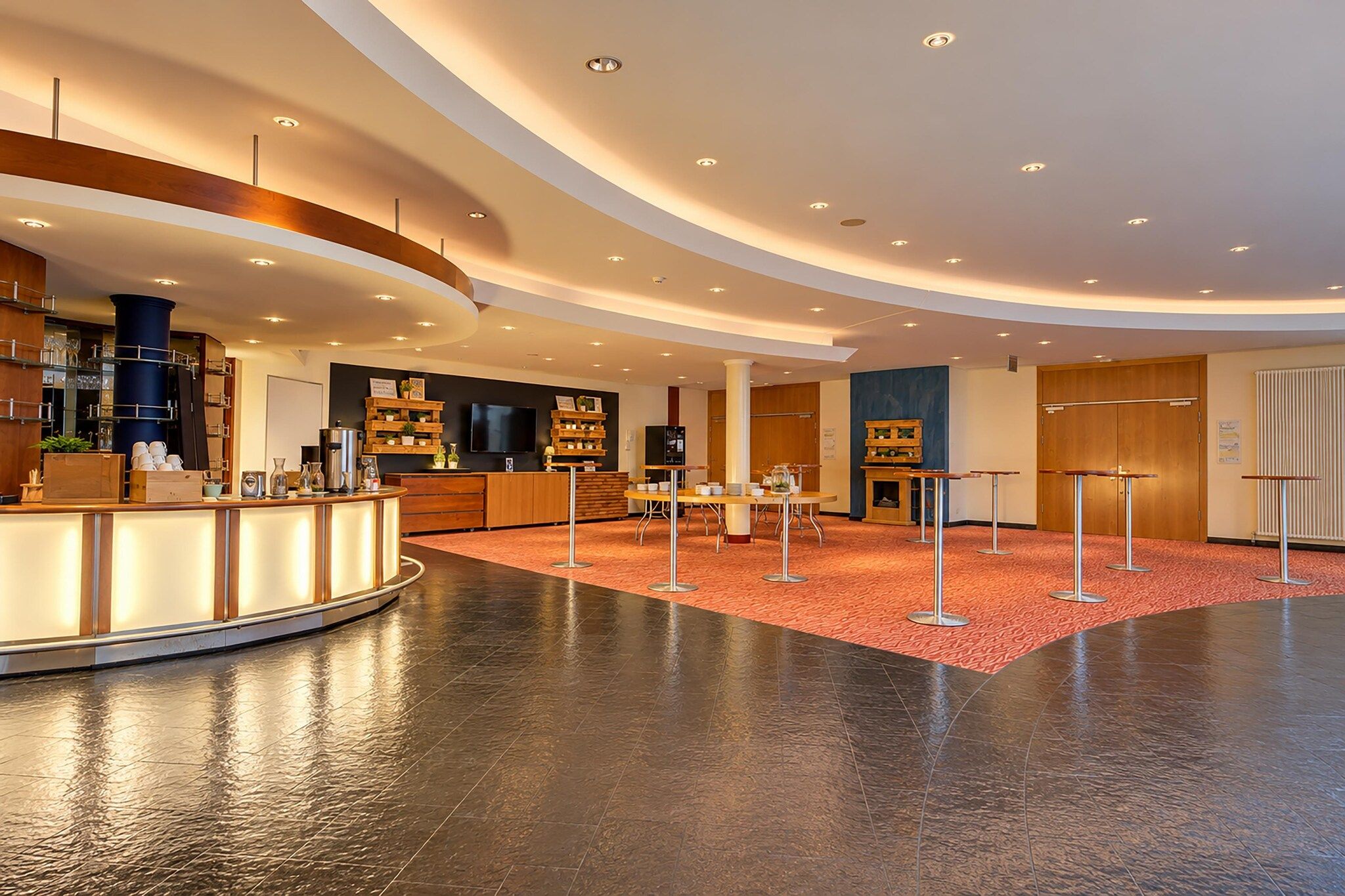 Eine moderne Lobby mit einer Rezeption, einer Sitzecke und einem Kamin.