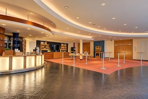 Un hall d’entrée moderne avec un comptoir d’accueil, un espace salon et une cheminée.