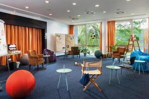 Una habitación con un escenario, asientos y ventanas amplias.