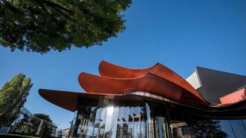 Un bâtiment moderne doté d’une structure de toit incurvée originale et de fenêtres en verre réfléchissant.
