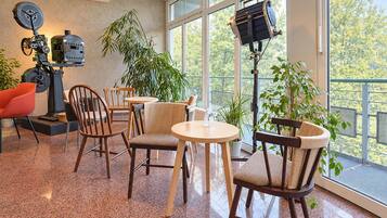 Un intérieur moderne comprenant un coin salon, de grandes fenêtres et un assortiment de meubles, notamment des chaises et des tables.