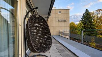 Un bâtiment moderne avec une enseigne indiquant « SEMINARIS » et une chaise en osier sur un balcon.