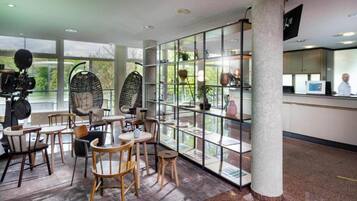 Un intérieur moderne comprenant un espace salon, un comptoir d’accueil et une vue dégagée grâce à une paroi en verre.