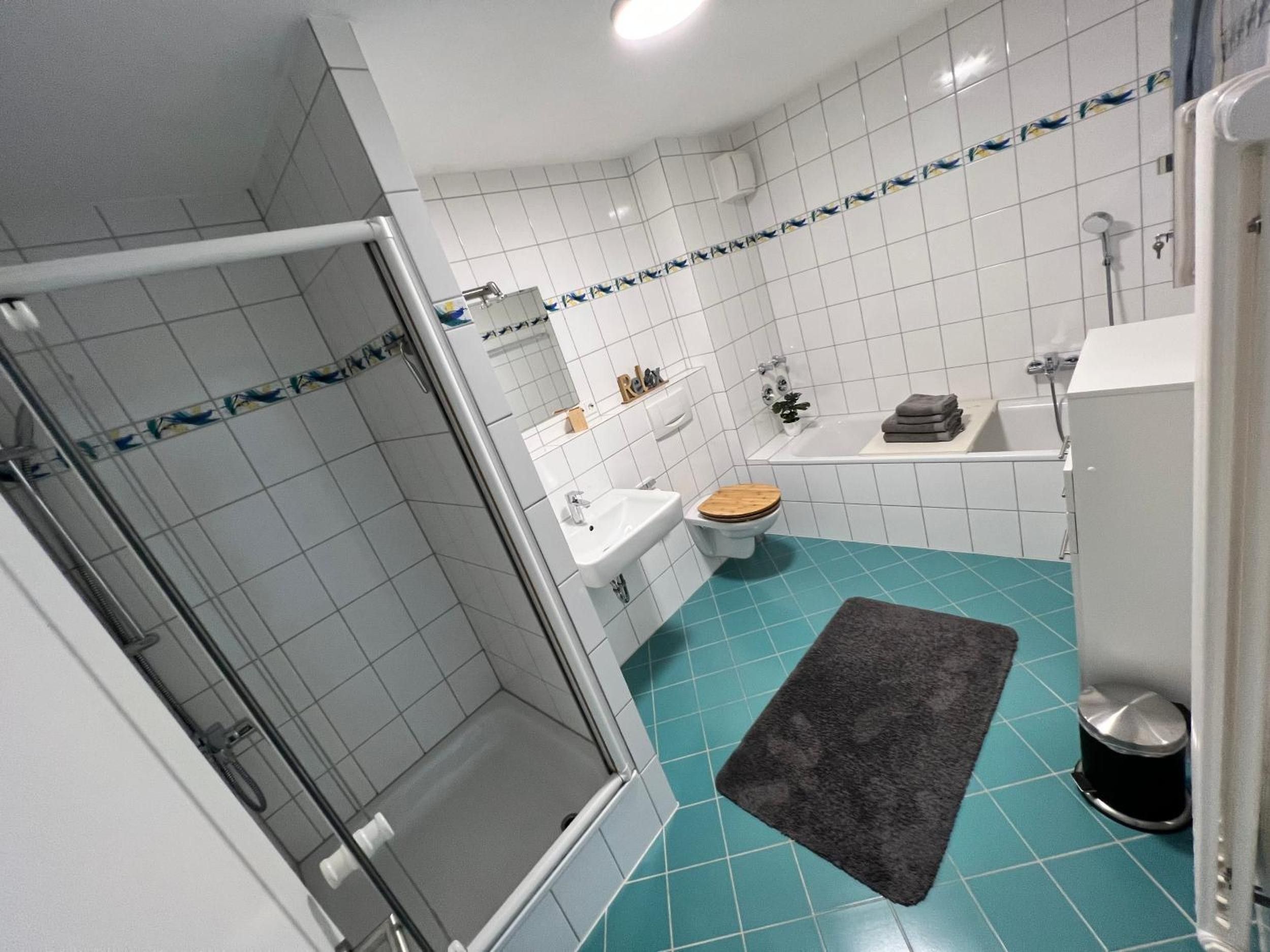 Un baño con ducha, inodoro, lavamanos y bañera.