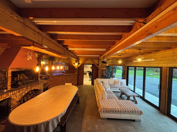 A cozy interior with a fireplace, seating area, and large windows.