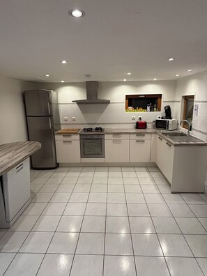 A modern kitchen with a stainless steel refrigerator, a microwave, a stove, and a sink.