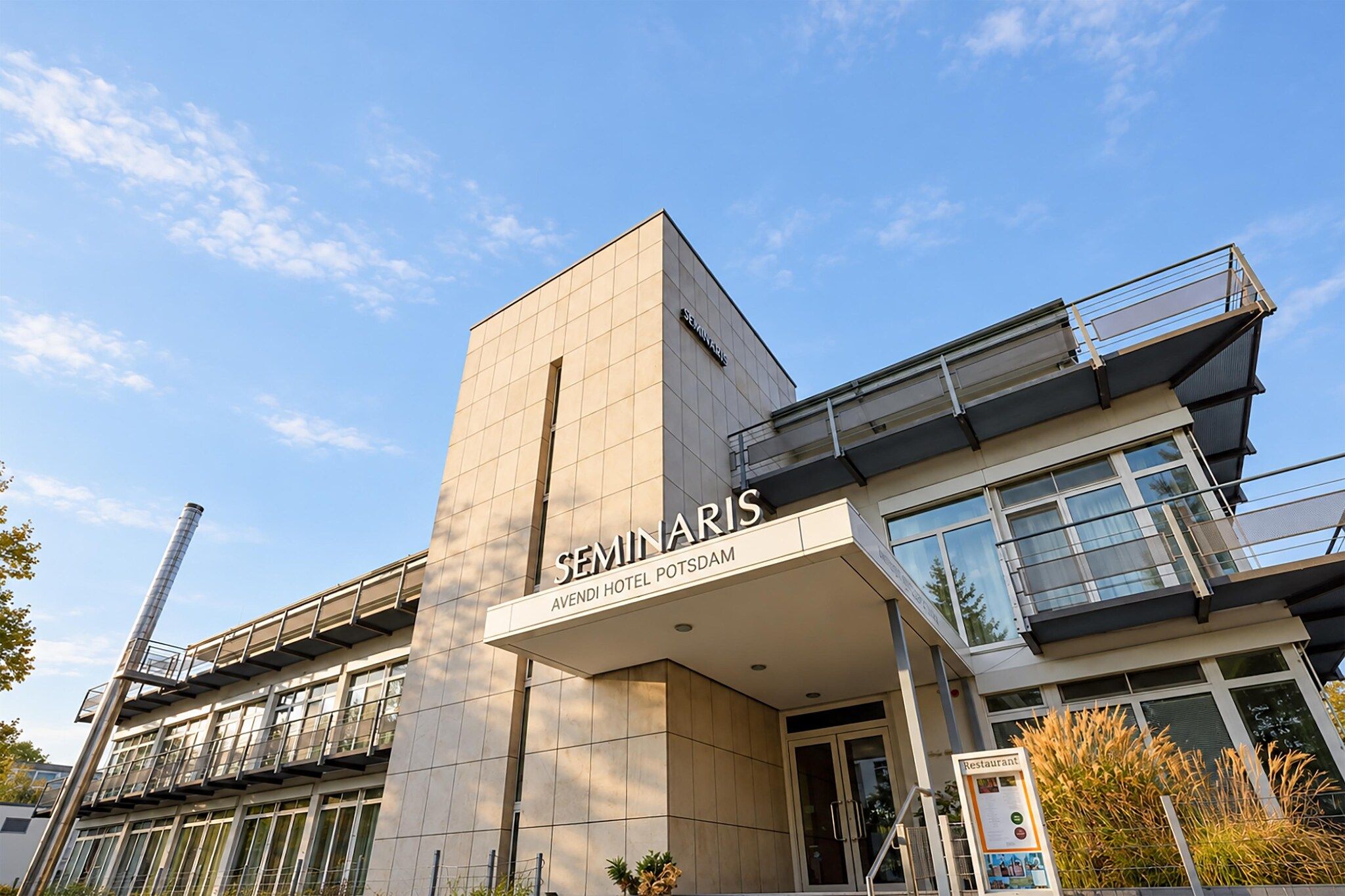 Un bâtiment moderne, orné d’une enseigne bien visible indiquant « SEMINARIS », ce qui laisse supposer qu’il s’agit d’un centre de séminaires ou de conférences.