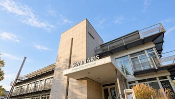 Un bâtiment moderne, orné d’une enseigne bien visible indiquant « SEMINARIS », ce qui laisse supposer qu’il s’agit d’un centre de séminaires ou de conférences.