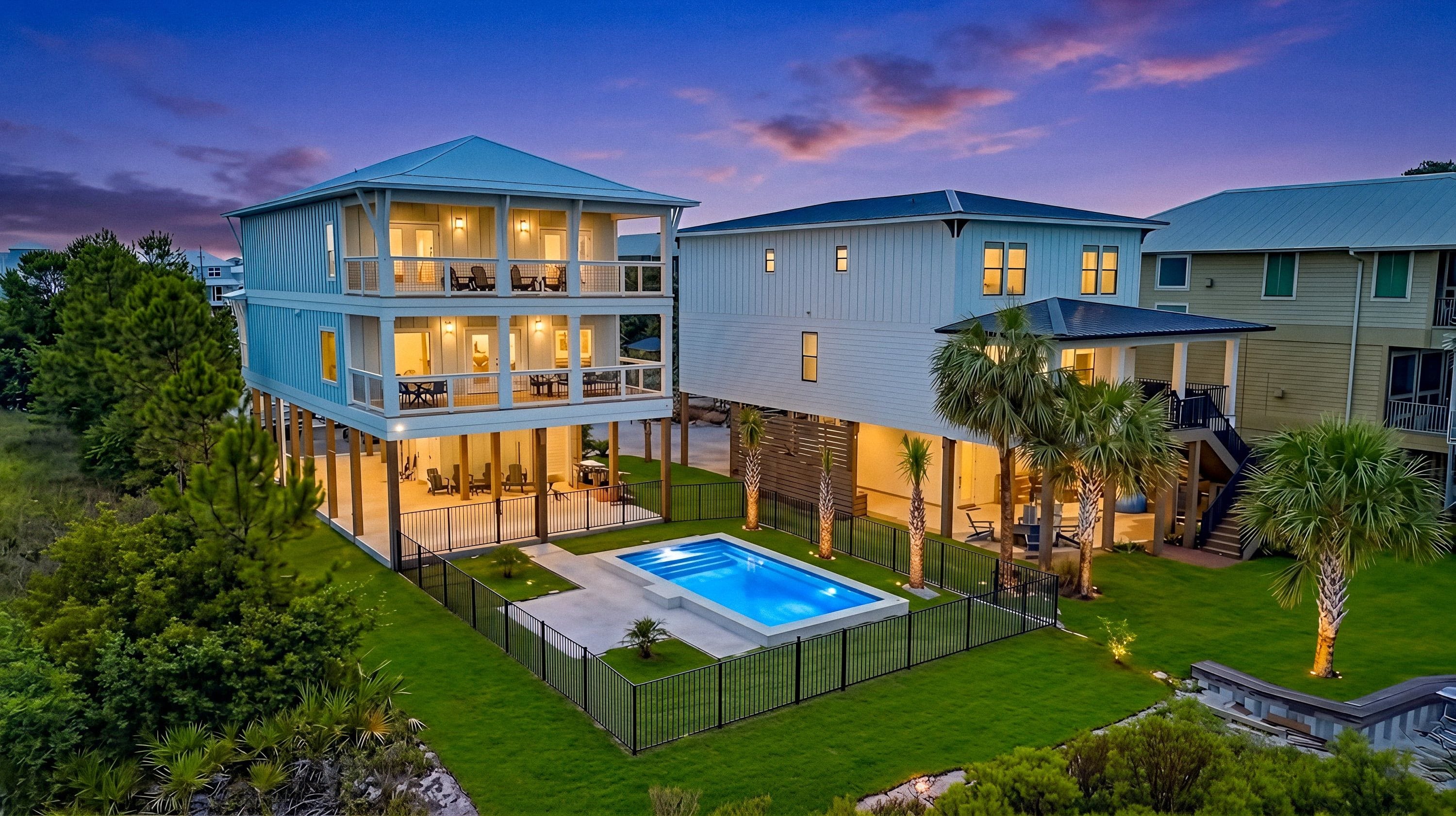 A two-story house with a swimming pool, a covered patio, and a well-maintained lawn.