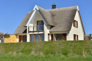 A house with a steeply pitched roof, large windows, and a balcony. - Holiday apartment with 2 bedrooms (Breege)