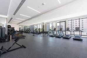 A gym with treadmills, weight machines, and dumbbells. - StayShort - Spacious 2-Bedroom Apartment at Skyhills Tower 1 (Arjan)
