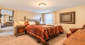 A bedroom with a bed, bedside table, lamp, and a framed picture on the wall. - Corporate Retreat: A Cottage in the City (Auburn Hills)
