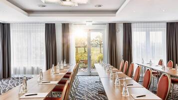A conference room with a long table, chairs, and a view of the outdoors.