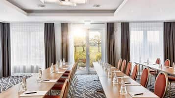 A conference room with a long table, chairs, and a view of the outdoors.